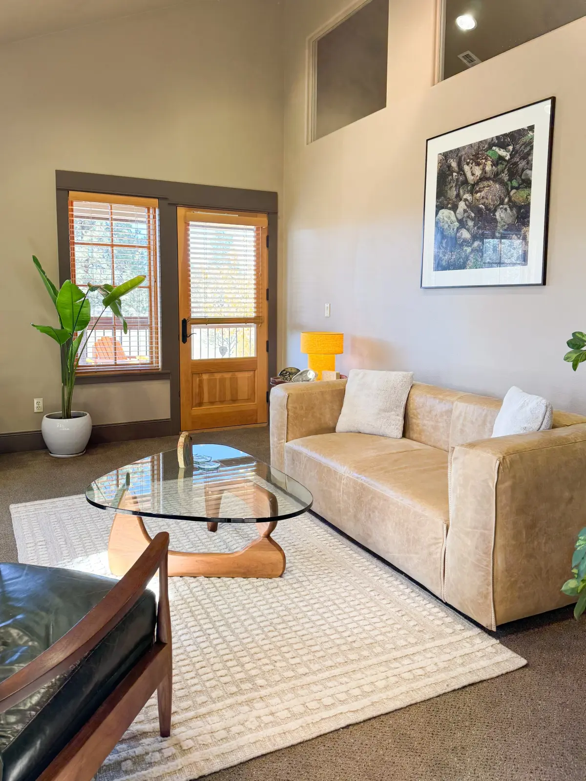 The Aspen Counseling waiting room in Sisters: a leather sofa, plants, and a wooden door opening onto the porch